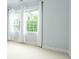 A brightly lit bedroom featuring neutral carpeting, and two windows with bright, white curtains at 3130 Woodwalk Se Trce # 8, Atlanta, GA 30339