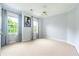 A bright bedroom featuring neutral carpet, two windows with blue curtains, and a ceiling fan at 3130 Woodwalk Se Trce # 8, Atlanta, GA 30339