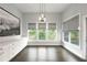 Bright dining area featuring dark wood floors, white cabinets and trim, pendant lighting, and large windows with gray roman shades at 3130 Woodwalk Se Trce # 8, Atlanta, GA 30339