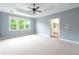 Spacious main bedroom with tray ceiling, ceiling fan, and bright windows at 3130 Woodwalk Se Trce # 8, Atlanta, GA 30339
