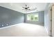 Large main bedroom with neutral carpet, tray ceiling, fan, and plentiful natural light from windows at 3130 Woodwalk Se Trce # 8, Atlanta, GA 30339