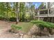 Lush backyard featuring a stone paver walkway, mature trees, and a covered porch for outdoor enjoyment at 3750 Maryhill Nw Ln, Kennesaw, GA 30152