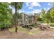 Expansive backyard featuring a multi-level deck, screened porch, lush greenery, and mature trees at 3750 Maryhill Nw Ln, Kennesaw, GA 30152