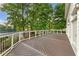 Large wooden deck with white railings offering a serene view of the surrounding greenery and tennis courts at 3750 Maryhill Nw Ln, Kennesaw, GA 30152