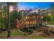 Multi-story home with screened porch, deck, lush backyard, mature trees and manicured lawn at sunset at 3750 Maryhill Nw Ln, Kennesaw, GA 30152
