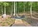 Inviting fire pit area nestled in a wooded backyard setting with stone steps and Adirondack chairs at 3750 Maryhill Nw Ln, Kennesaw, GA 30152