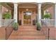 Inviting brick porch with classic columns, a double-door entrance, and potted plants creating a warm ambiance at 3750 Maryhill Nw Ln, Kennesaw, GA 30152