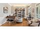 Cozy living room with hardwood floors, a piano, a built-in bookcase, and comfortable seating at 3750 Maryhill Nw Ln, Kennesaw, GA 30152