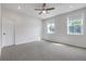 Spacious bedroom featuring gray carpet, two windows with natural light, and a modern ceiling fan at 776 Clifftop Xing Xing, Powder Springs, GA 30127