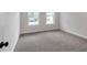Neutral bedroom featuring wall-to-wall carpet and two large windows at 776 Clifftop Xing Xing, Powder Springs, GA 30127