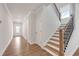 Inviting hallway features hardwood floors, neutral walls, and staircase with black metal spindles at 776 Clifftop Xing Xing, Powder Springs, GA 30127