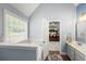 Bright bathroom with a tub, window, and view to the main bedroom at 107 Hearthstone Walk, Woodstock, GA 30189