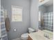 Well-lit bathroom featuring a toilet, vanity with sink, and shower-tub combination with a striped curtain at 107 Hearthstone Walk, Woodstock, GA 30189