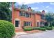Brick townhome showcasing a symmetrical design with dark shutters and meticulously maintained landscaping at 3074 Vinings Ridge Se Dr, Atlanta, GA 30339