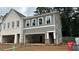 New townhome exterior featuring a modern design with siding, brick accents, and a garage at 174 Bluffington Way, Marietta, GA 30066