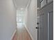 Long hallway with hardwood flooring leading towards a bright window and gray front door at 174 Bluffington Way, Marietta, GA 30066