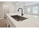 Kitchen island featuring quartz countertops, stainless sink, and black hardware at 174 Bluffington Way, Marietta, GA 30066