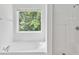 Bright bathroom featuring a tub, shower, and window with natural light at 1955 Pius Dr, Ellenwood, GA 30294