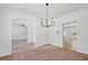 Open dining room featuring modern light fixture, neutral walls and flooring, and view into the kitchen at 1955 Pius Dr, Ellenwood, GA 30294