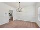 Dining room with modern chandelier, white walls, and view into the kitchen with stainless appliances at 1955 Pius Dr, Ellenwood, GA 30294