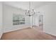 Dining room featuring large window, neutral walls and flooring, and modern light fixture at 1955 Pius Dr, Ellenwood, GA 30294