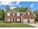 Charming two-story brick home with a well-manicured lawn and attached two-car garage at 1955 Pius Dr, Ellenwood, GA 30294
