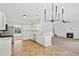 Open kitchen with white cabinets, stainless appliances, and view into the living room with fireplace at 1955 Pius Dr, Ellenwood, GA 30294