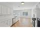 Bright kitchen with white cabinets, stainless steel appliances, tile backsplash, and linoleum floors at 1955 Pius Dr, Ellenwood, GA 30294