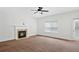 Bright living room featuring a fireplace, carpeted floors, ceiling fan, and natural light at 1955 Pius Dr, Ellenwood, GA 30294