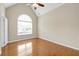 Bedroom featuring a vaulted ceiling, hardwood floors, and a large arched window at 231 Yardsley Dr, Mcdonough, GA 30253