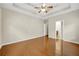 Bright bedroom with hardwood floors, tray ceiling, and a ceiling fan at 231 Yardsley Dr, Mcdonough, GA 30253