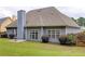 Rear exterior with a well-manicured lawn, patio with table, and mature landscape at 231 Yardsley Dr, Mcdonough, GA 30253