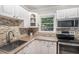 Well-lit kitchen featuring mosaic backsplash, stainless steel appliances, and white cabinetry at 286 Indian Trl, Marietta, GA 30068