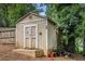 An outdoor storage shed with double doors and some yard maintenance tools at 286 Indian Trl, Marietta, GA 30068
