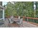 Enjoy the serene backyard view from the spacious wooden deck with outdoor seating at 6425 Riley Manor Way, Cumming, GA 30028