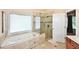 Bright bathroom with a corner soaking tub, glass-enclosed shower, and tiled flooring at 6425 Riley Manor Way, Cumming, GA 30028