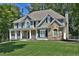 Inviting two-story home with a stone facade, covered porch and landscaped front yard at 6425 Riley Manor Way, Cumming, GA 30028