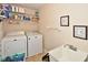Functional laundry room with washer, dryer, sink, and shelving for efficient storage at 6425 Riley Manor Way, Cumming, GA 30028