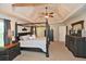 Spacious main bedroom with a tray ceiling, fan, and dark furniture at 6425 Riley Manor Way, Cumming, GA 30028