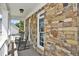 Inviting side porch with stone wall, rocking chairs, and a relaxing outdoor space at 6425 Riley Manor Way, Cumming, GA 30028