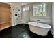 Bathroom featuring black tiled floor, glass shower, soaking tub, and window view at 115 Palisade Dr, Rydal, GA 30171