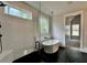 Bright bathroom features a glass shower, standalone tub, and dark hexagon tile flooring with access to the main bedroom at 115 Palisade Dr, Rydal, GA 30171