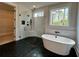 Bathroom featuring black tiled floor, glass shower, soaking tub, and window view at 115 Palisade Dr, Rydal, GA 30171