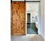 Barn door opens to a bathroom with a glass shower, standalone tub, and striking black tile flooring at 115 Palisade Dr, Rydal, GA 30171
