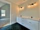 Elegant bathroom with double vanity, modern lighting, and sleek black tile floors offers a luxurious space at 115 Palisade Dr, Rydal, GA 30171