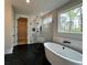 Spacious bathroom with a freestanding tub, walk-in shower, black hexagon tile flooring, and serene outdoor views at 115 Palisade Dr, Rydal, GA 30171