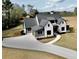 Lovely two-story home with a white brick and siding exterior, a gray roof, and a spacious driveway at 115 Palisade Dr, Rydal, GA 30171