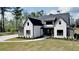 Stunning two-story home boasts a modern farmhouse design with black trim and a manicured front lawn at 115 Palisade Dr, Rydal, GA 30171