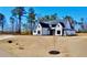 Beautifully designed house with white brick, black roof, and a large lot, set back from the street at 115 Palisade Dr, Rydal, GA 30171