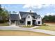 Charming two-story home featuring a white brick facade, dark roof, long driveway, and lush green lawn at 115 Palisade Dr, Rydal, GA 30171